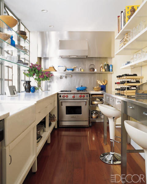 The kitchen of a Manhattan townhouse designed by Temple St. Clair features Carrara-marble counters and a custom-made stainless-steel hood and storage unit; the stove is by Wolf.
